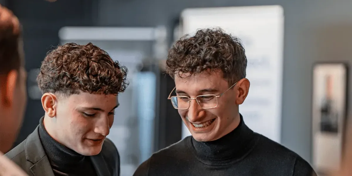 Zwei junge Berater schauen gemeinsam auf ihre Smartphones
